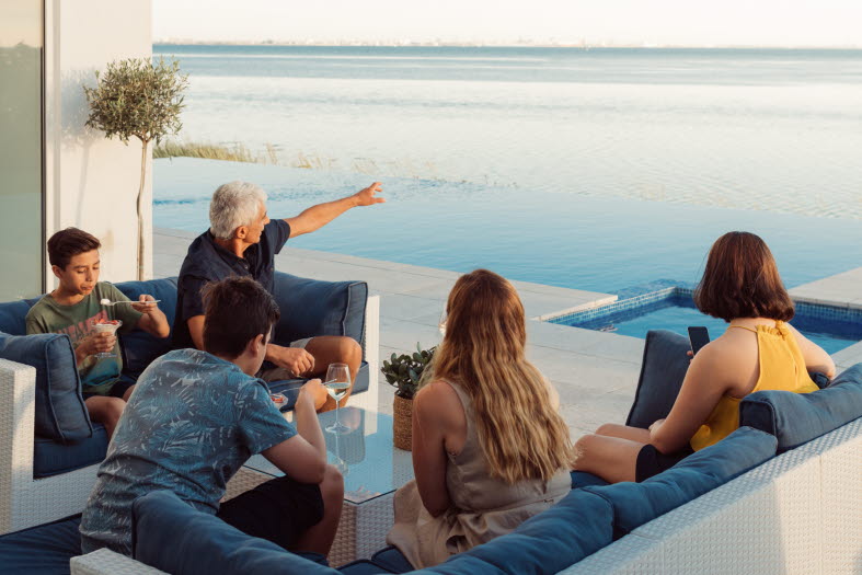 Famlij som sitter vid havet och blickar ut Famlij som sitter vid havet och blickar ut
