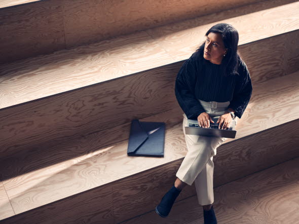 Kvinna på jobbet som sitter vid sitt skrivbord
