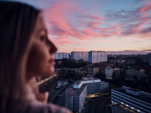 Kvinna som ser ut över hustaken i Solna, Stockholm