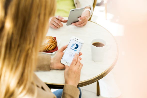 Person med en moibl i handen som visar mobilt BankID