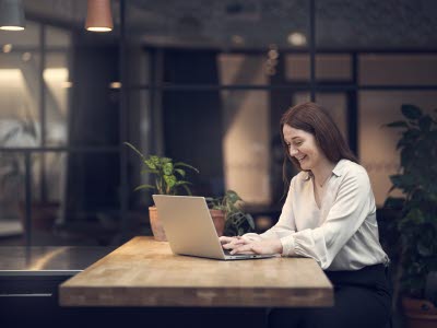 Kvinna som sitter framför sin laptop.