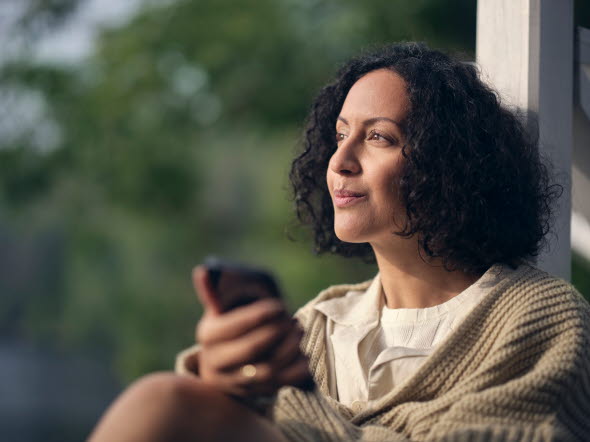 Woman with a phone looking into the horizon