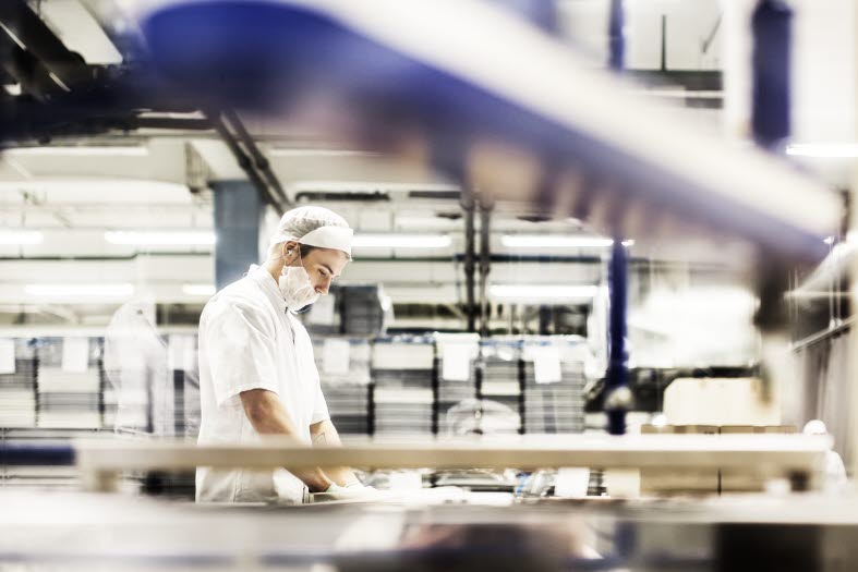 En manlig industriarbetare står och arbetar En manlig industriarbetare står och arbetar