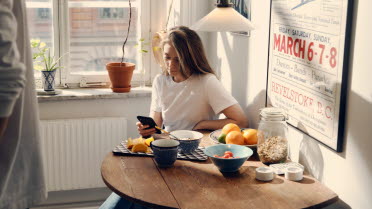 Ung kvinna vid frukostbordet.