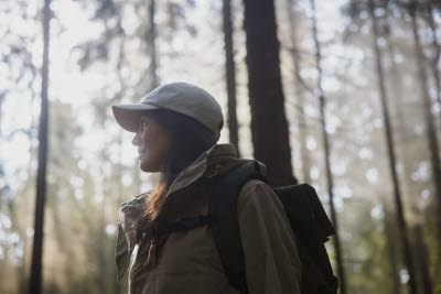 Ung kvinna i skogen på vandring.
