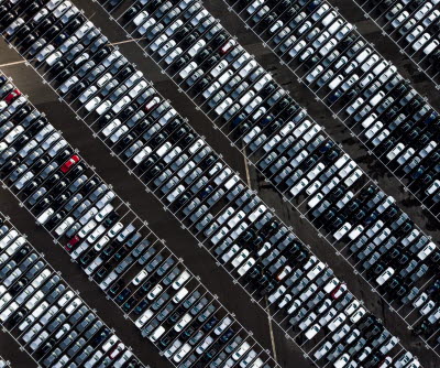 En stor parkeringsplats med flertalet bilar parkerade. Bild tagen ovanifrån.
