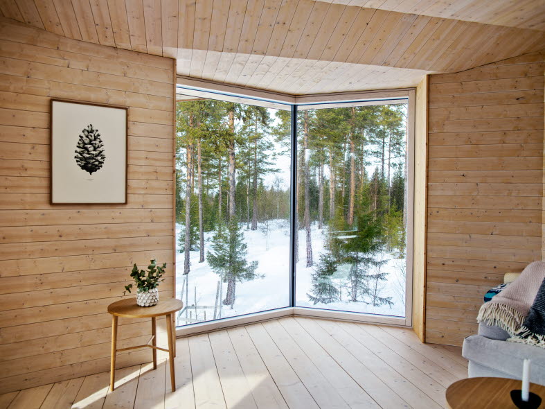 Glasparti i ett rum helt i trä som blickar ut mot vinterlandskap.